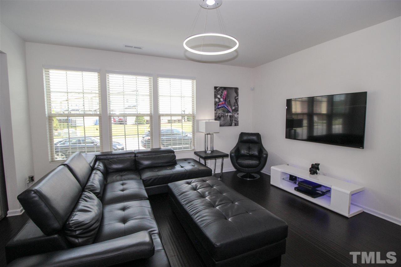 1045 Grand Ridge Drive Rolesville, NC 27571 - Photo 5 of 23 a living room with furniture and a flat screen tv