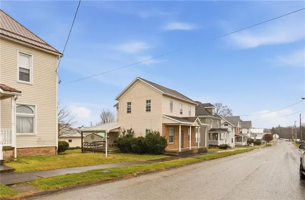 a view of a house with a big yard and large trees