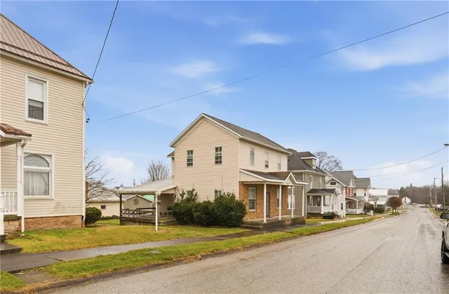 a view of a house with a big yard and large trees