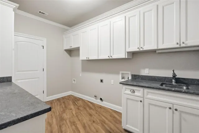 a kitchen with granite countertop white cabinets and a sink