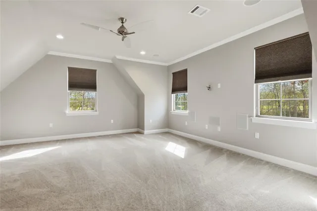 an empty room with windows and ceiling fan