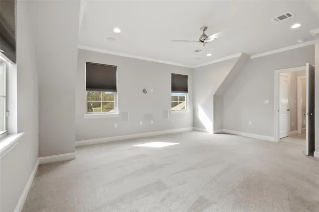 an empty room with windows and ceiling fan