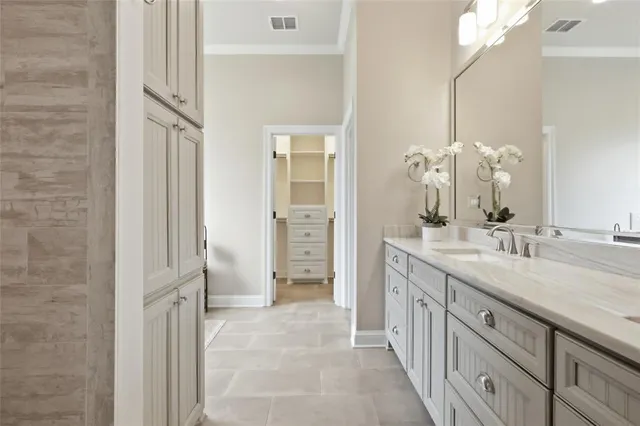 a spacious bathroom with a double vanity sink a large mirror and a shower