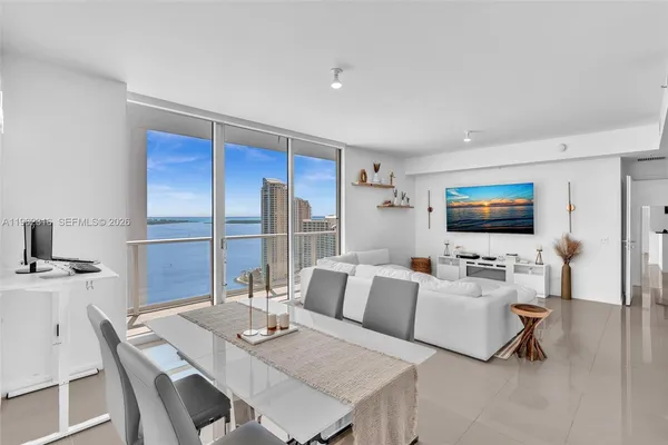 a living room with furniture a flat screen tv and a table