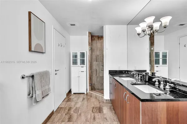 a bedroom with a large bed and a chandelier