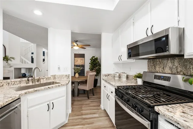 a kitchen with stainless steel appliances granite countertop a sink stove and microwave