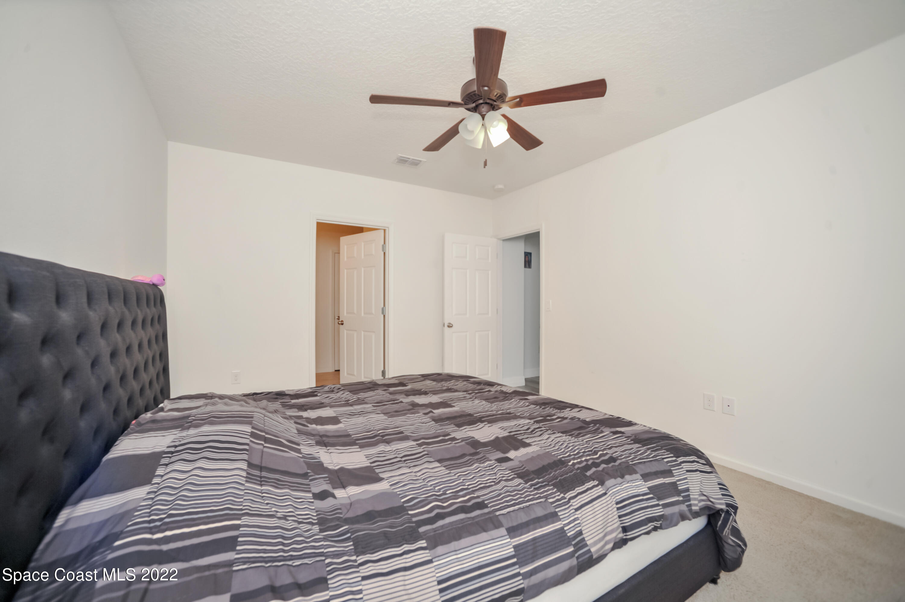 4720 Pagosa Springs Circle Melbourne, FL 32901 - Photo 16 of 24 a bedroom with a bed and a chandelier