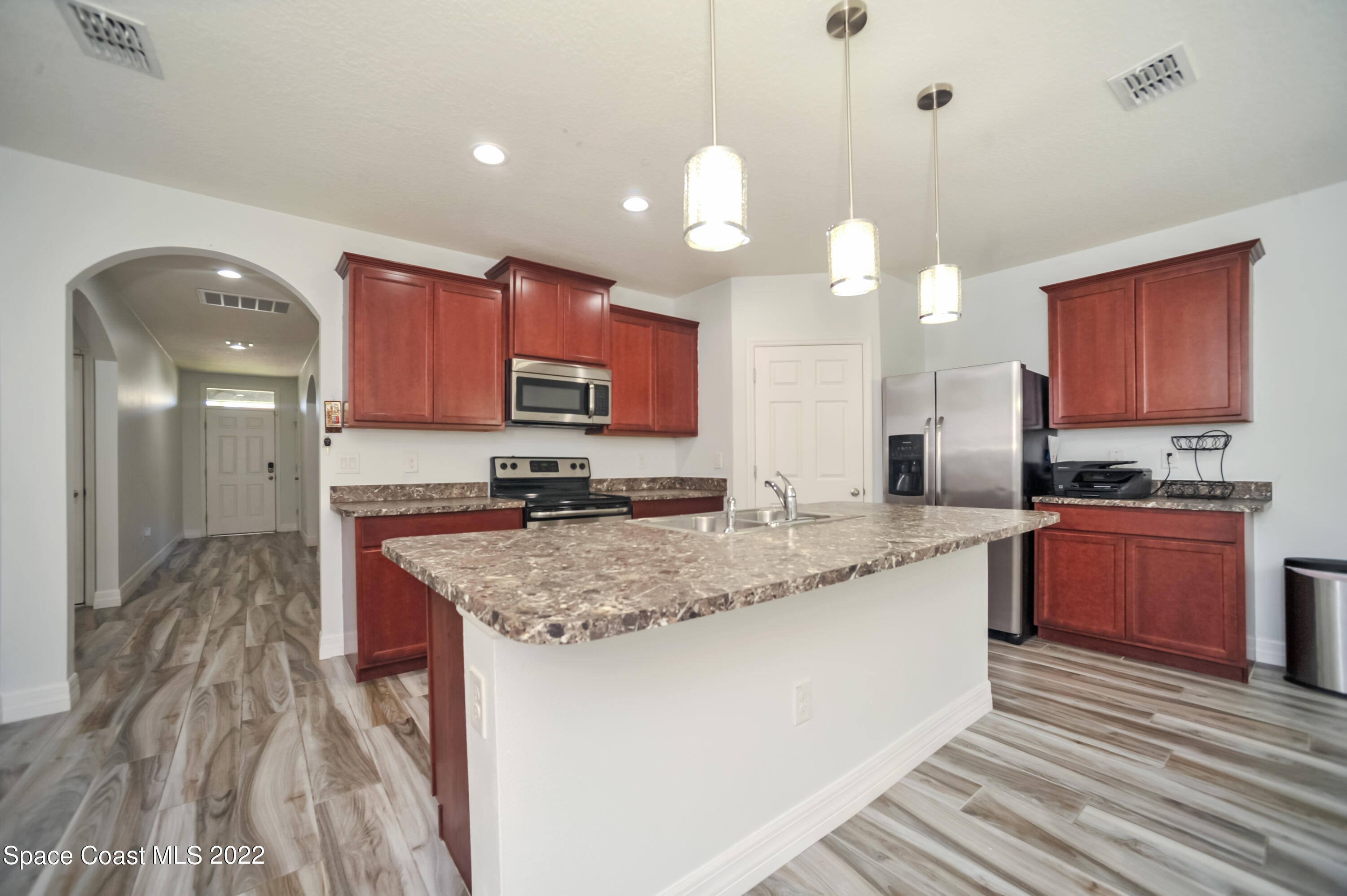 4720 Pagosa Springs Circle Melbourne, FL 32901 - Photo 3 of 24 a kitchen with stainless steel appliances granite countertop a sink a stove and a wooden floors