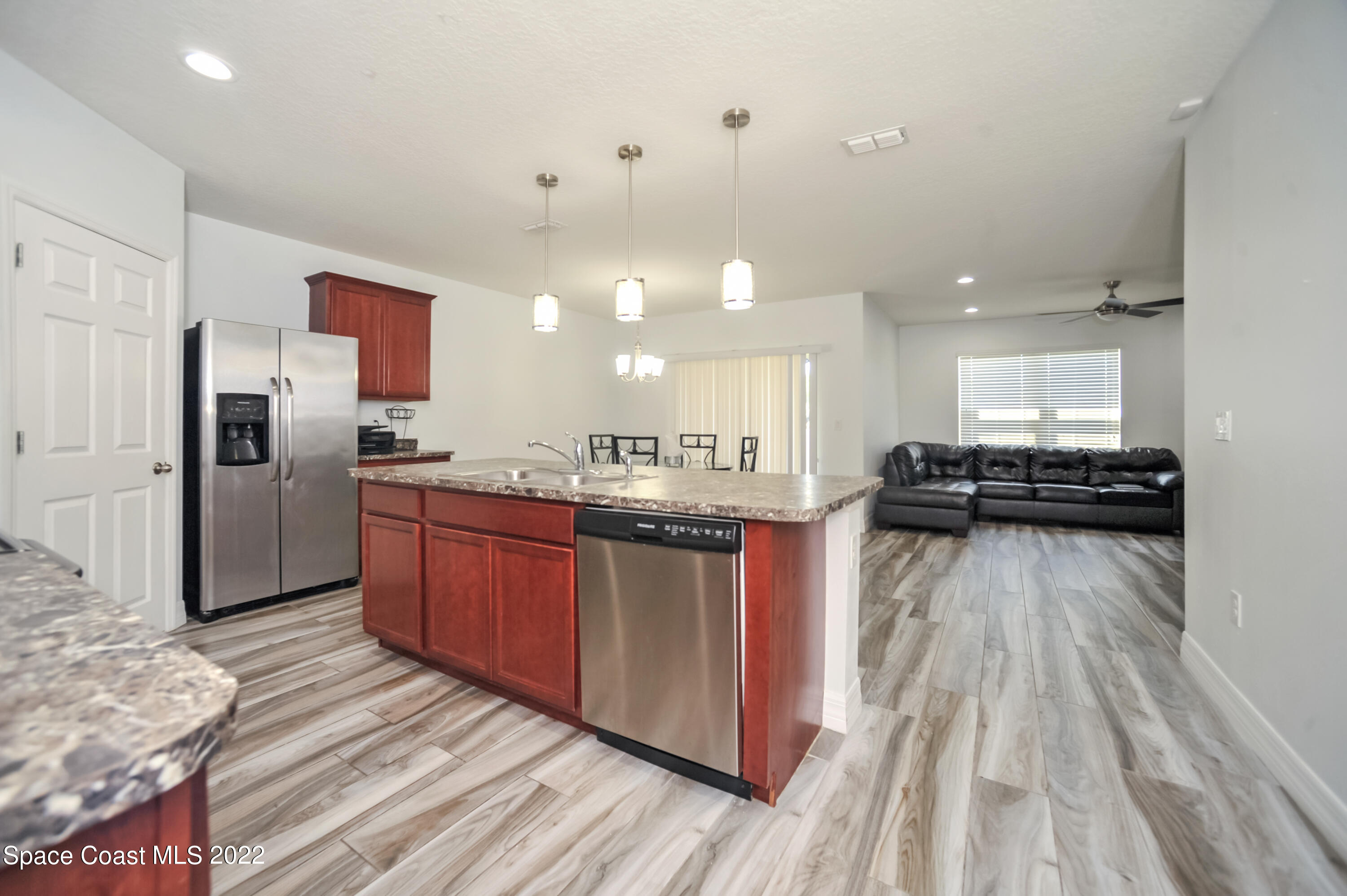4720 Pagosa Springs Circle Melbourne, FL 32901 - Photo 4 of 24 a kitchen with stainless steel appliances granite countertop a refrigerator a stove and a wooden floors