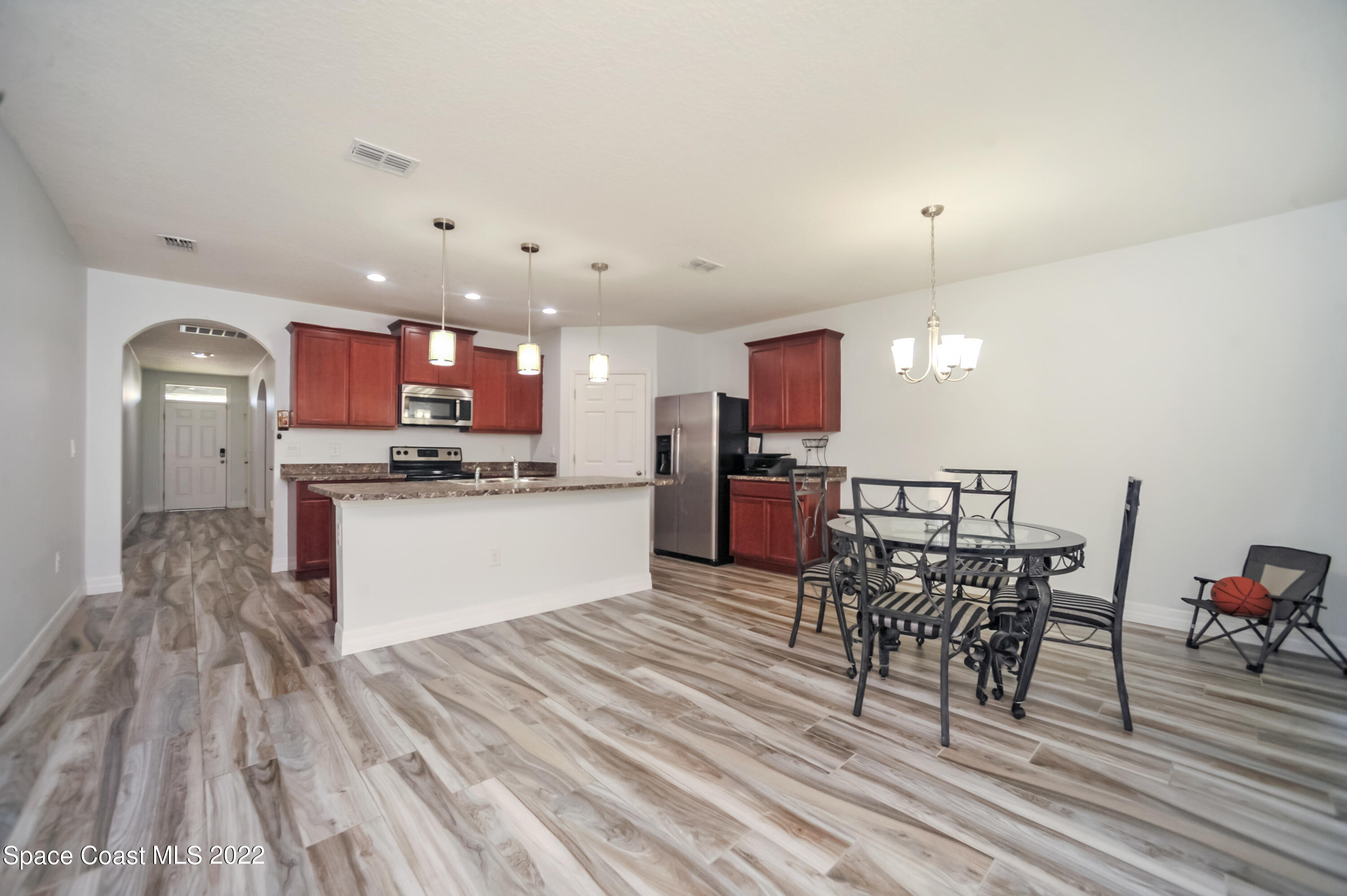 4720 Pagosa Springs Circle Melbourne, FL 32901 - Photo 5 of 24 a kitchen with stainless steel appliances kitchen island granite countertop a table chairs sink and cabinets