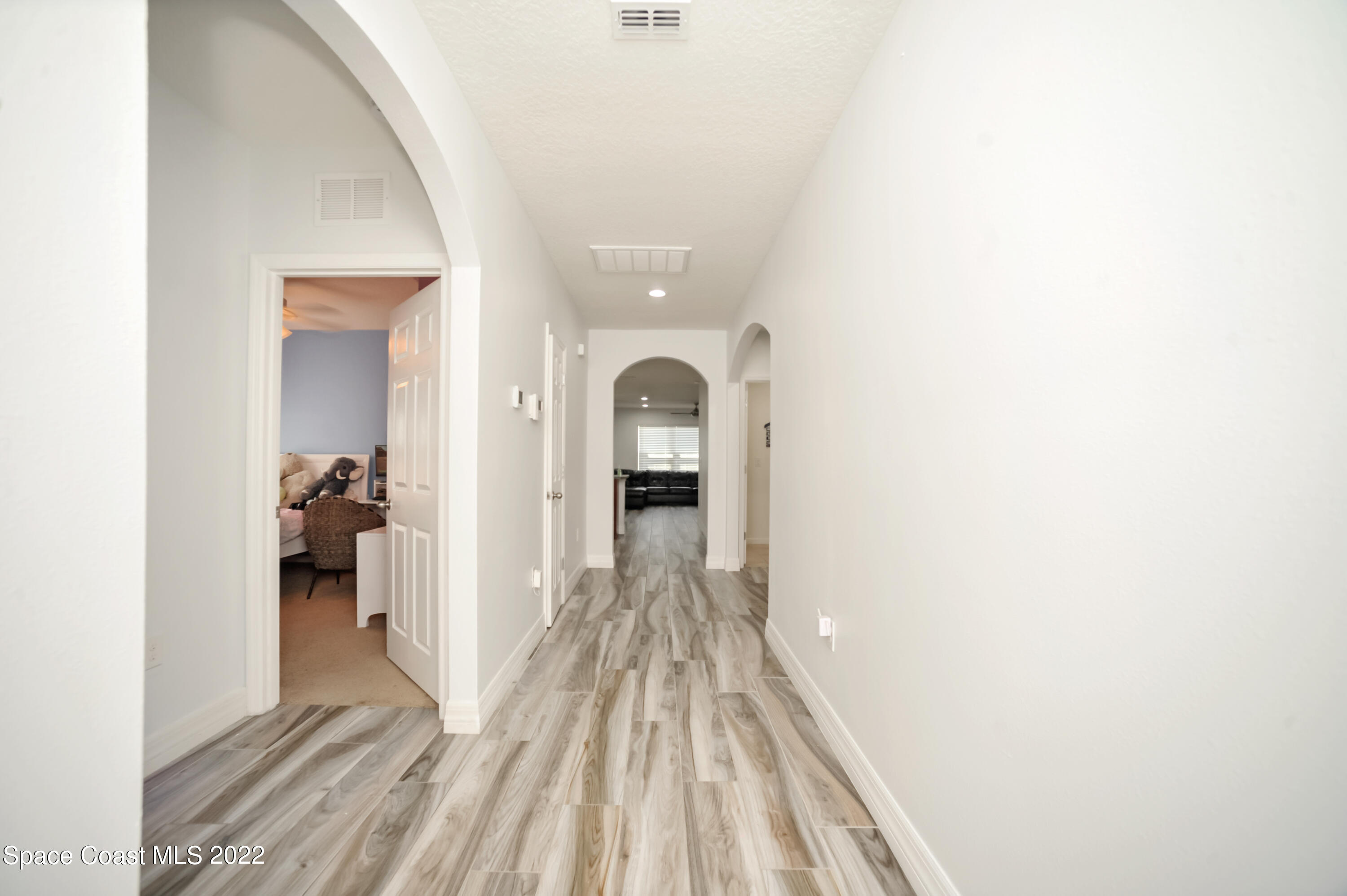 4720 Pagosa Springs Circle Melbourne, FL 32901 - Photo 7 of 24 a view of a hallway with wooden floor and a bathroom