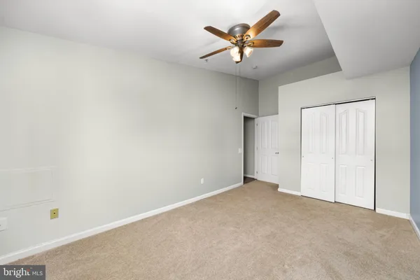 an empty room with a ceiling fan and a window