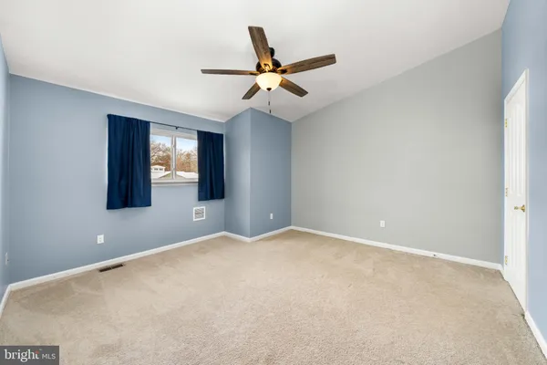 an empty room with closet and windows