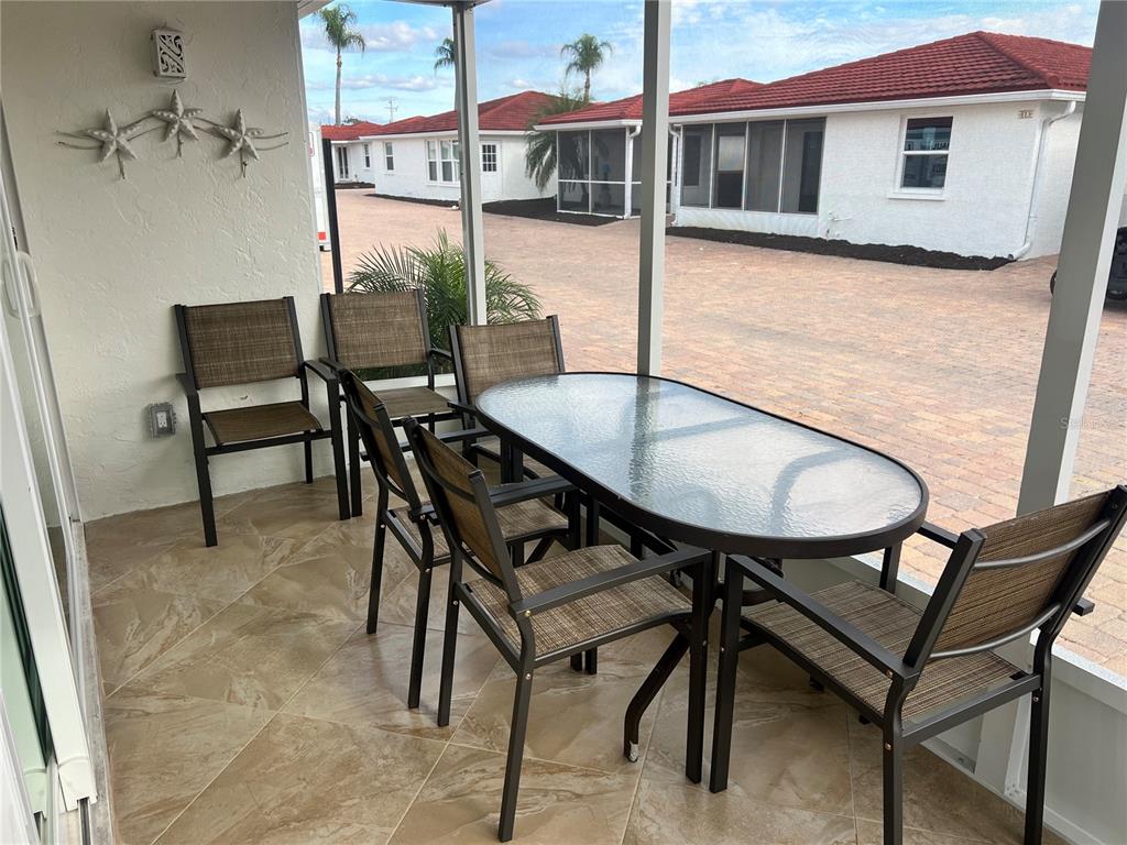 6154 Midnight Pass Road, Unit A14 Sarasota, FL 34242 - Photo 13 of 13 a balcony with table and chairs