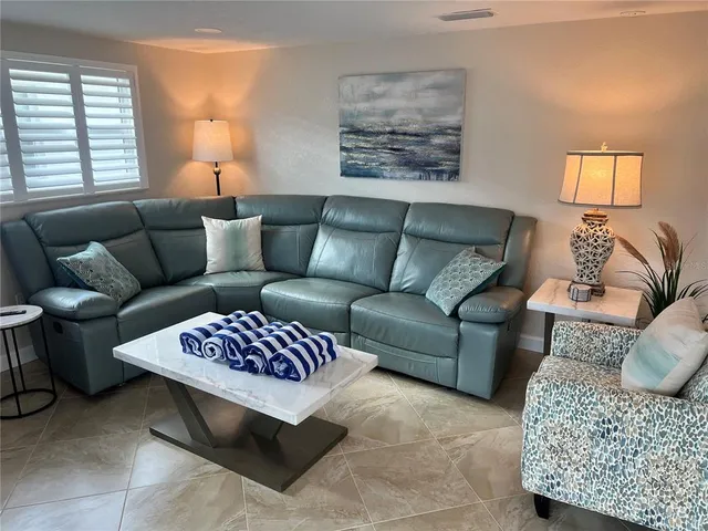 a living room with furniture ceiling fan and a window