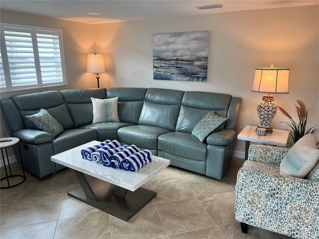 6154 Midnight Pass Road, Unit A14 Sarasota, FL 34242 - Photo 2 of 13 a living room with furniture ceiling fan and a window