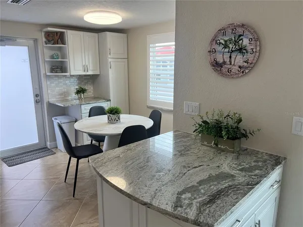 a kitchen with a table chairs and a refrigerator