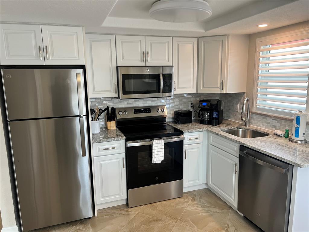 6154 Midnight Pass Road, Unit A14 Sarasota, FL 34242 - Photo 5 of 13 a kitchen with a refrigerator stove and sink