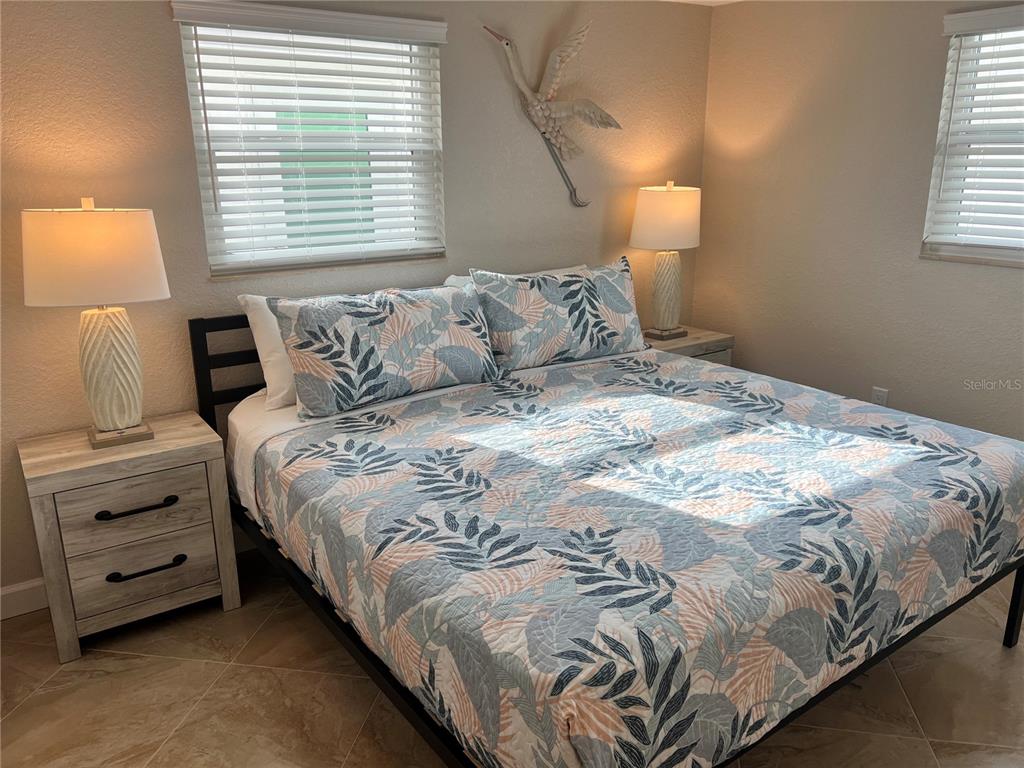 6154 Midnight Pass Road, Unit A14 Sarasota, FL 34242 - Photo 10 of 13 a large bed sitting in a bedroom next to a window