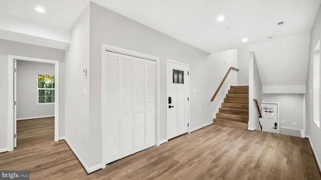 en view of a hallway with wooden floor and staircase