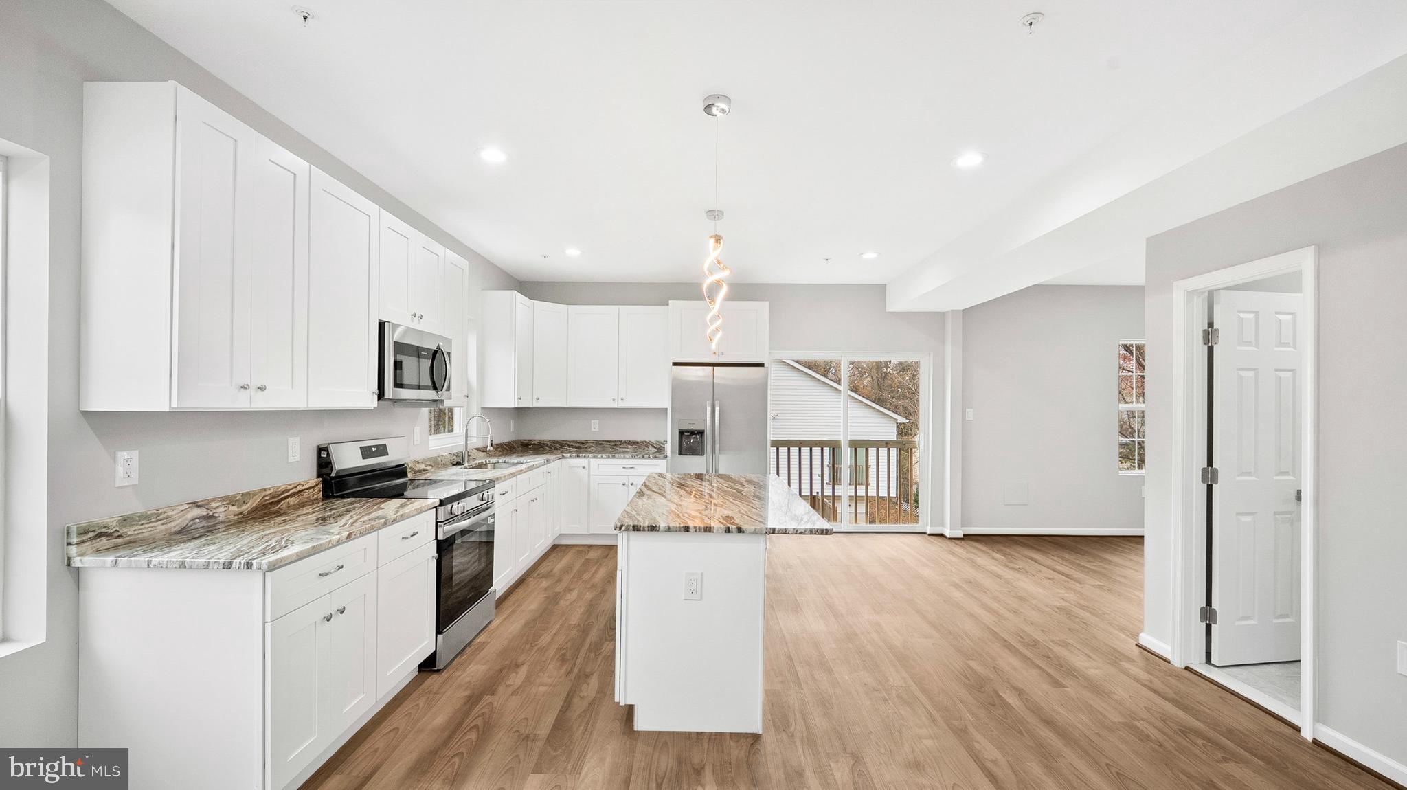 921 Balboa Avenue Capitol Heights, MD 20743 - Photo 7 of 37 a large white kitchen with stainless steel appliances granite countertop a lot of counter space and wooden floor