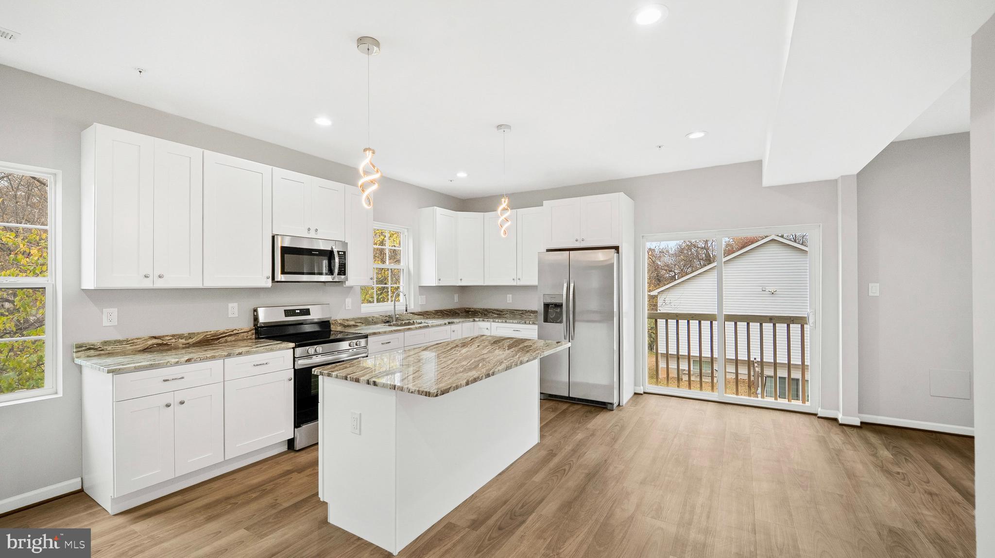 921 Balboa Avenue Capitol Heights, MD 20743 - Photo 8 of 37 a kitchen with stainless steel appliances granite countertop a stove top oven a sink a refrigerator and white cabinets with wooden floor