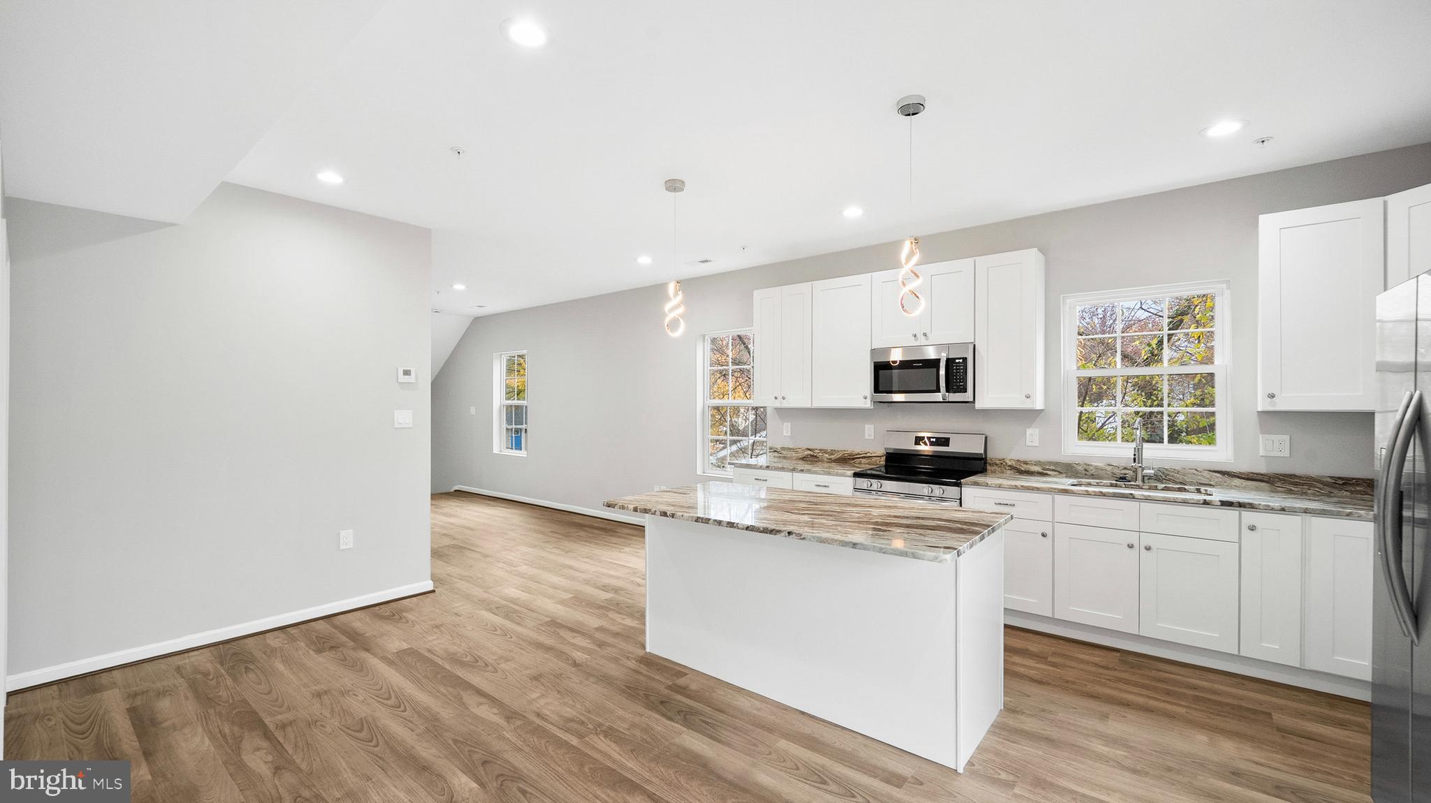 921 Balboa Avenue Capitol Heights, MD 20743 - Photo 9 of 37 a kitchen with stainless steel appliances granite countertop a stove top oven a sink a refrigerator and white cabinets with wooden floor