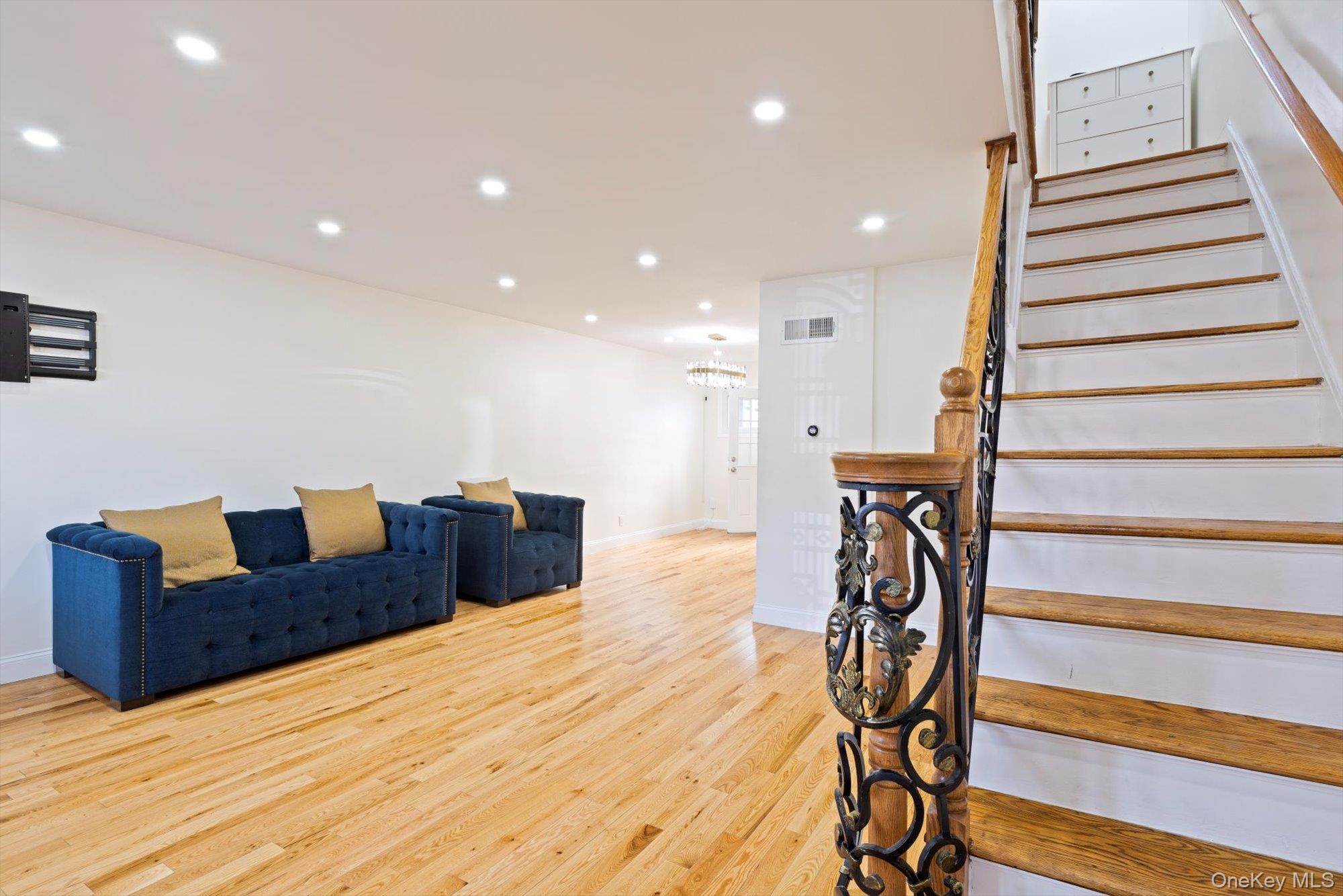 144-14 68th Avenue Queens, NY 11367 - Photo 2 of 15 a living room with furniture and a stair