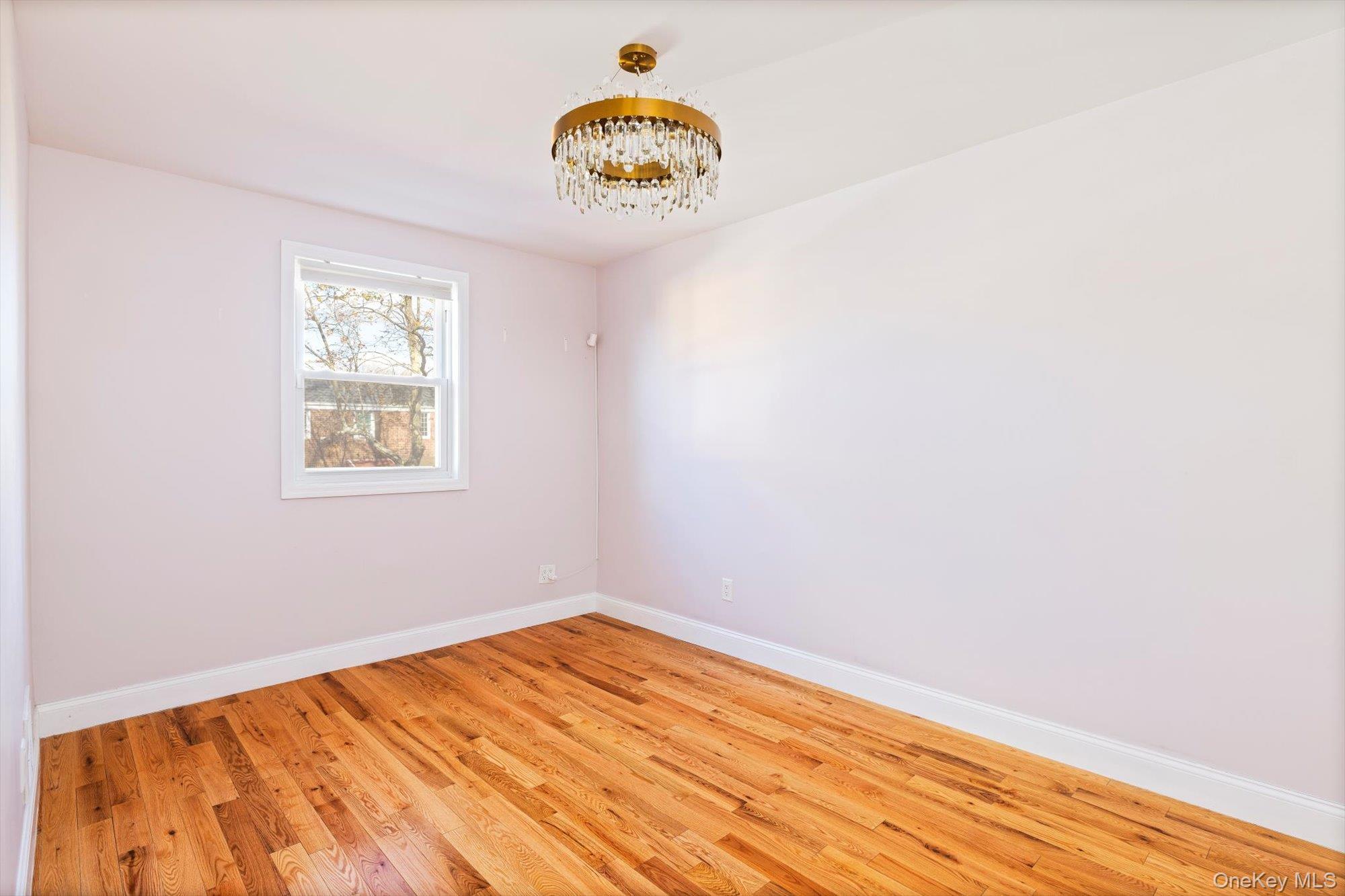 144-14 68th Avenue Queens, NY 11367 - Photo 8 of 15 a view of a room with wooden floor and a window