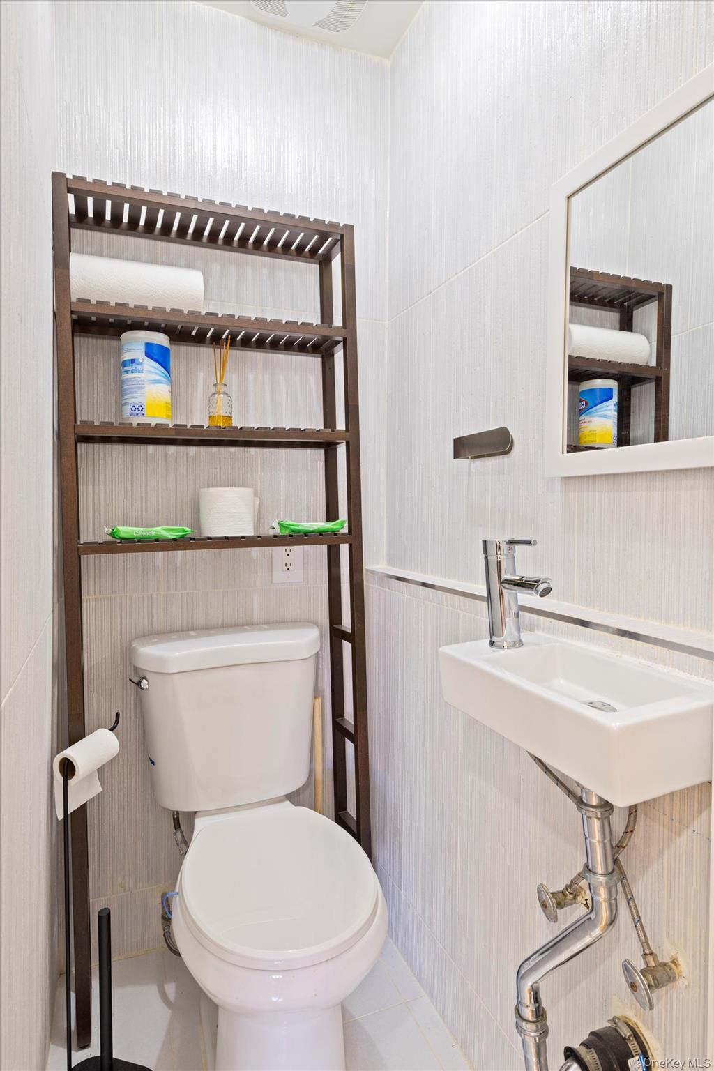 144-14 68th Avenue Queens, NY 11367 - Photo 10 of 15 a bathroom with a toilet a sink and a mirror