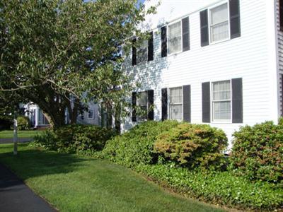 101 Depot Road, Unit 18 Chatham, MA 02633 - Photo 2 of 16 a view of a brick house with a yard and plants