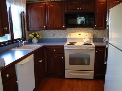 101 Depot Road, Unit 18 Chatham, MA 02633 - Photo 8 of 16 a kitchen with stainless steel appliances granite countertop a stove a sink and a microwave