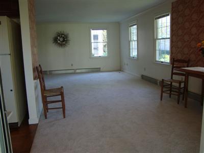 101 Depot Road, Unit 18 Chatham, MA 02633 - Photo 9 of 16 an empty room with windows and chair