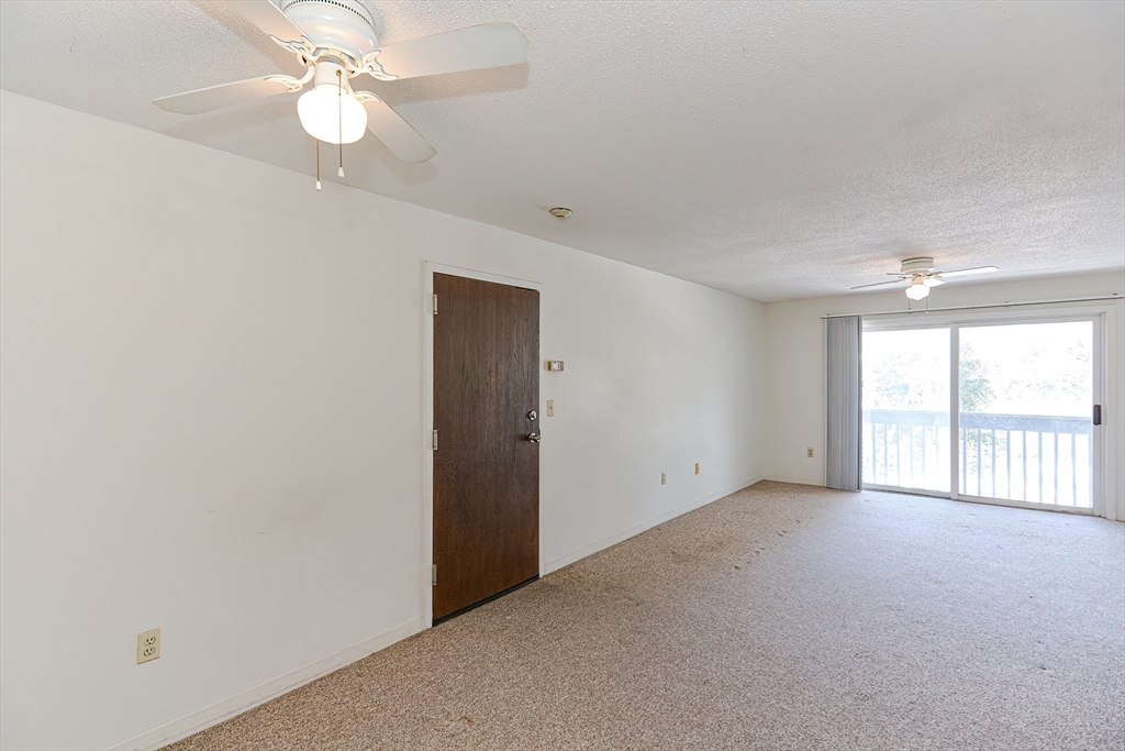 1811 Franklin Crossing Road, Unit 1811 Franklin, MA 02038 - Photo 11 of 31 an empty room with chandelier fan and windows