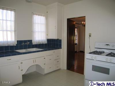 927 Atchison Street Pasadena, CA 91104 - Photo 6 of 13 a kitchen with granite countertop white cabinets and refrigerator