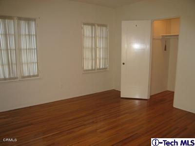 927 Atchison Street Pasadena, CA 91104 - Photo 10 of 13 an empty room with wooden floor and windows