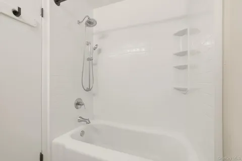 a bathroom with a bath tub with a shower