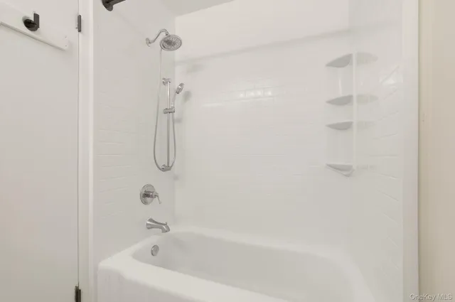 a bathroom with a bath tub with a shower