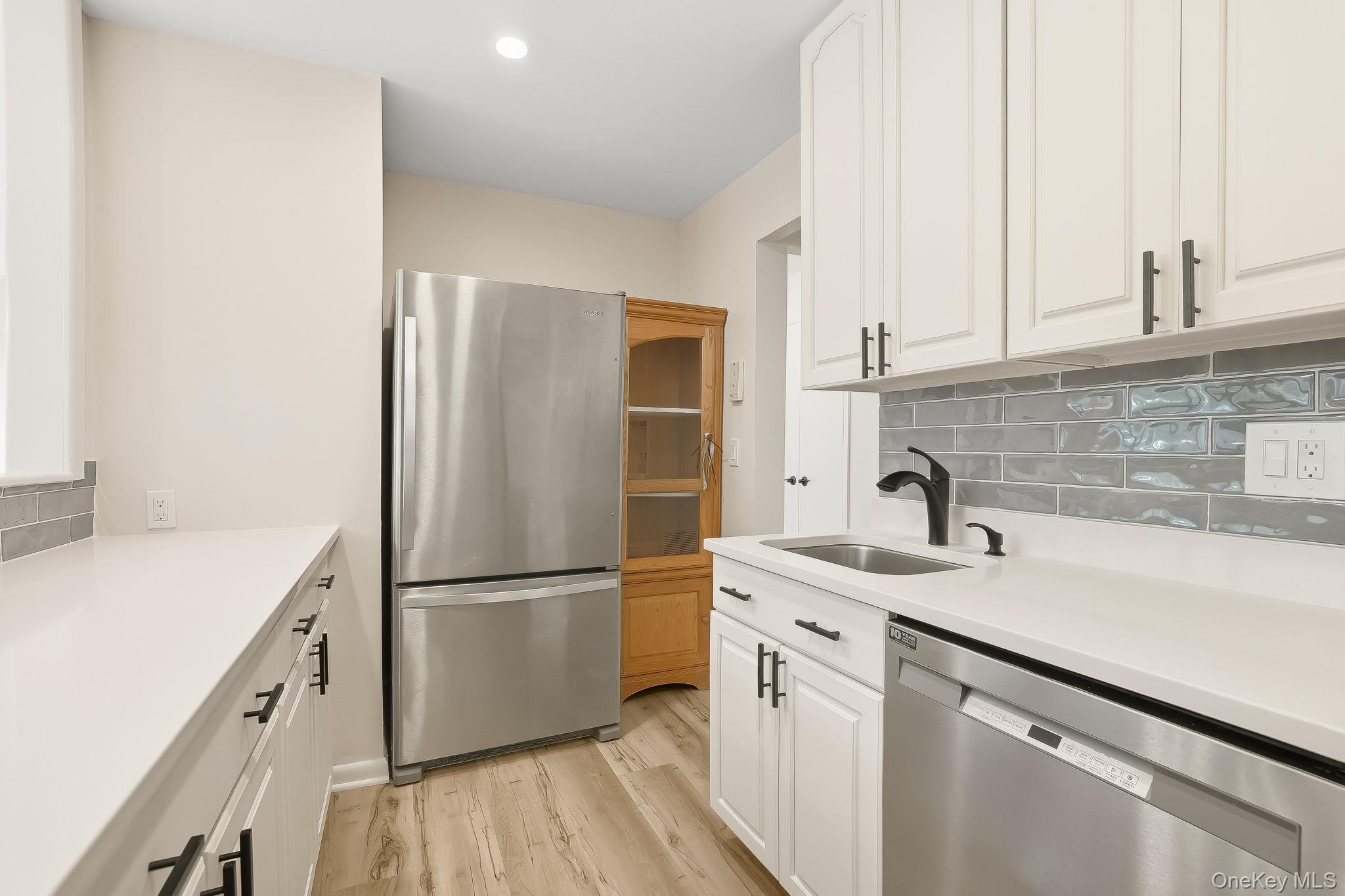150 Bedford Road, Unit 12A Chappaqua, NY 10514 - Photo 8 of 17 a kitchen with a sink and a refrigerator