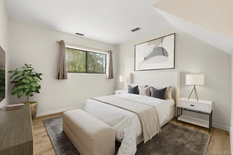 a bedroom with a bed and a potted plant