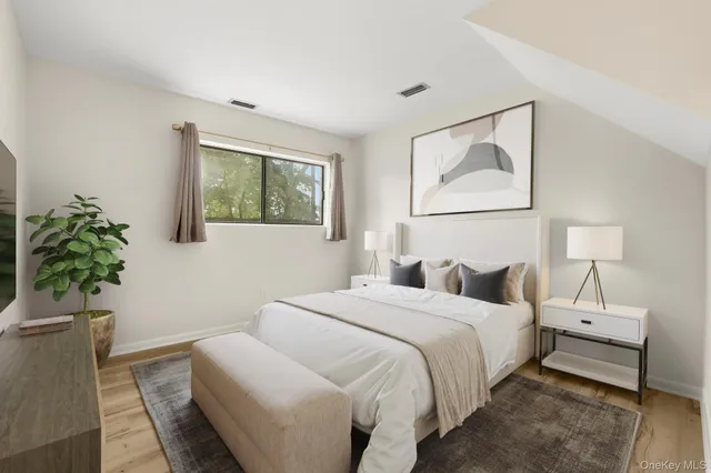 a bedroom with a bed and a potted plant