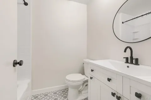 a bathroom with a sink a toilet and a mirror