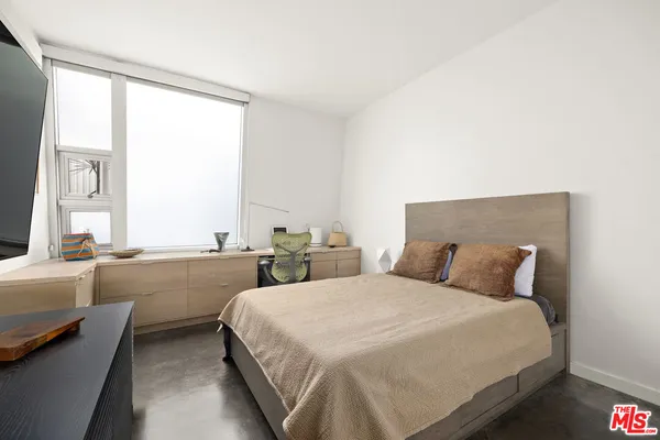 a bedroom with two beds and a large window