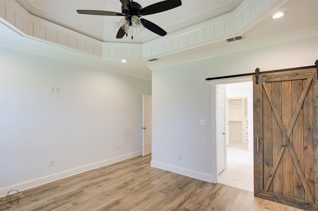 605 Meridian Way Benton, LA 71006 - Photo 23 of 29 Wood-finish flooring complementing a tray ceiling with board and batten trim and recessed lighting