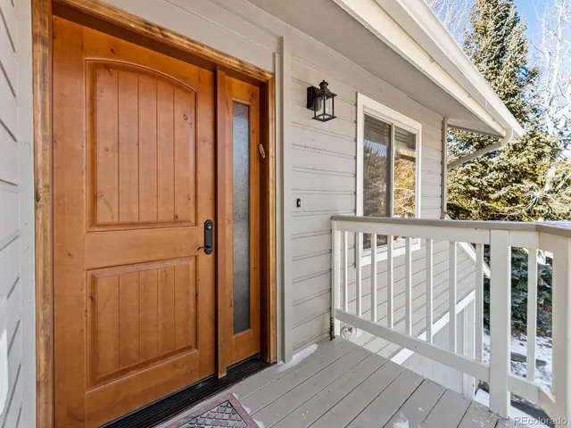 a living room with furniture stairs and a large window