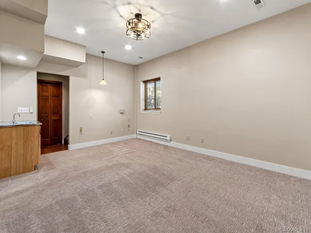 a bedroom with a large bed a painting on the wall and a large window