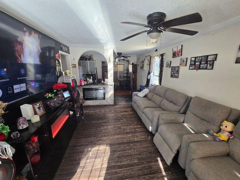 3530 Crow Road Memphis, TN 38108 - Photo 4 of 11 Living room with a textured ceiling, dark hardwood / wood-style floors, and ornamental molding