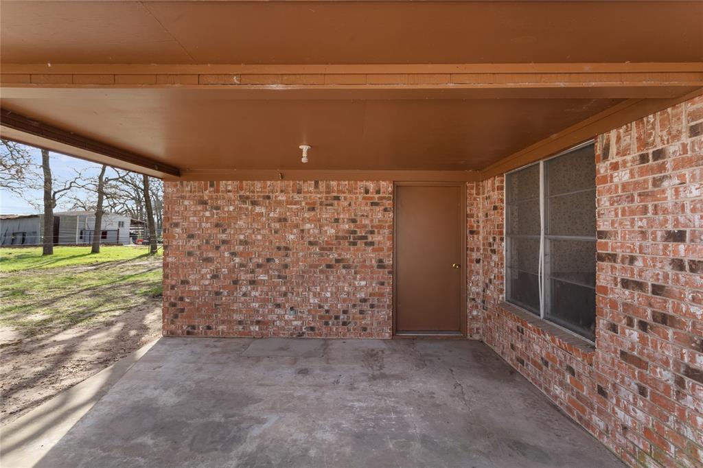 1447 Red Gate Road Mart, TX 76664 - Photo 21 of 38 a view of a room with sliding door and tree in the background