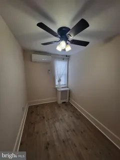 en empty room with wooden floor and a ceiling fan