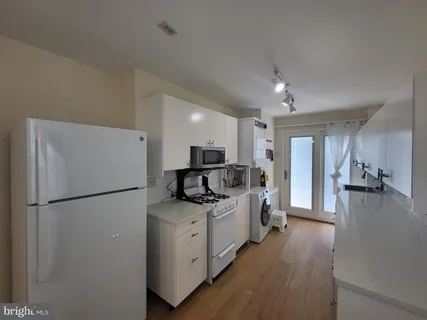 a kitchen with sink refrigerator and cabinets
